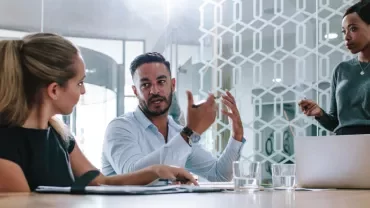 Three people having a meeting in a modern office.